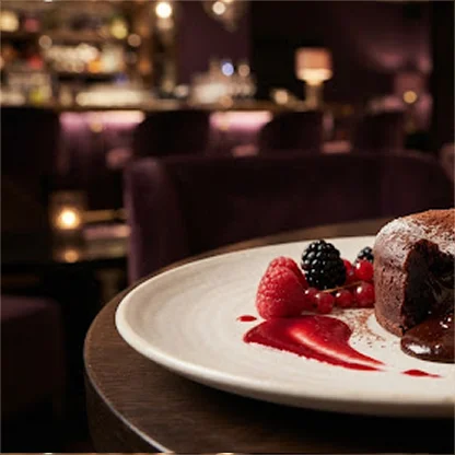 Fondant au chocolat fondant accompagné de framboises, mûres et d'un coulis de fruits rouges.