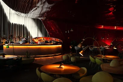 Intérieur d'un bar moderne et élégant avec un comptoir rétroéclairé, des lampes design et un éclairage d'ambiance chaleureux.